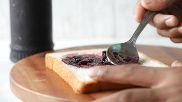 Spreading blueberry jam on slice of white bread video
