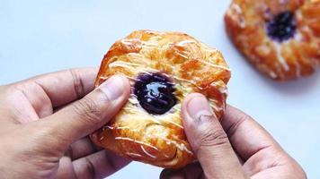 A blueberry pastry being parted with hands video