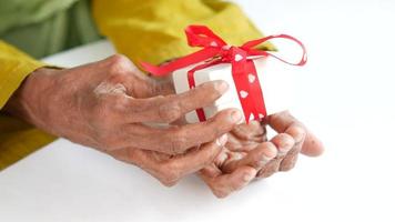 Mature hands hold a wrapped gift video