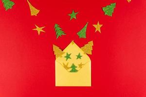 New Year red background with golden envelope and paper star and tree, flat lay photo