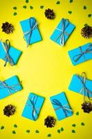 fondo amarillo azul navidad y año nuevo con caja de regalo y decoraciones, endecha plana. concepto de tarjeta de felicitación para vacaciones foto