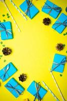 fondo amarillo azul navidad y año nuevo con caja de regalo y decoraciones, endecha plana. concepto de tarjeta de felicitación para vacaciones foto
