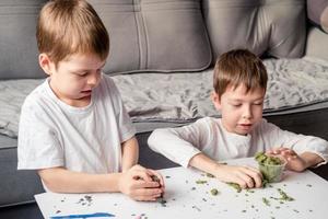 children play with Kinetic sand at home. Development of fine motor skills. photo