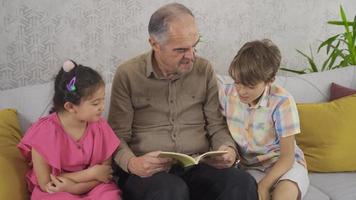 opa liest seinen enkeln vor. sachkundiger Großvater, der seinen Enkelkindern vorliest. video