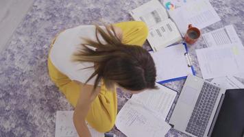 laps de temps d'une femme occupée et de documents papier sur le terrain. femme travaillant sur le sol avec des papiers de travail. video