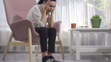 mujer triste sentada sola y llorando. la mujer sentada junto a la ventana en casa está llorando y triste. video