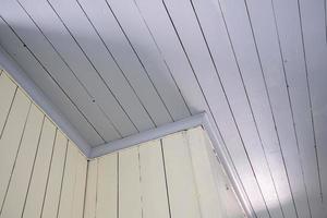 Ceiling and walls are made of wooden planks painted in white and grey. Bottom view. photo