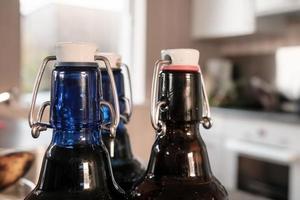 Three bottles of beer, closed with convenient caps, on a blurred background. photo