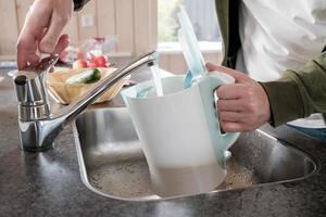 Filling with water electric kettle in the sink from the faucet photo