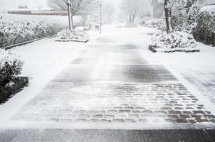 snow-covered european city, road on the street with private houses and trees photo