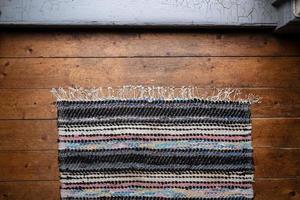 Multicolored rug on an old wooden floor. Top view. photo