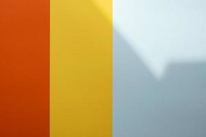 fondo de colores rojo, amarillo y gris con una sombra. rayas verticales de colores de diferentes anchos. copie el espacio foto