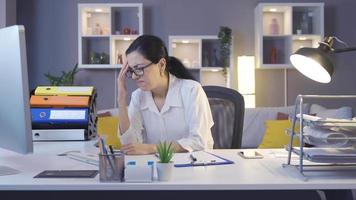 företag kvinna arbetssätt i Hem kontor har en huvudvärk. kvinna med huvudvärk ser på dator och studerar handla om arbete. video