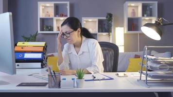 geschäftsfrau, die im home office arbeitet, hat kopfschmerzen. frau mit kopfschmerzen, die auf den computer schaut und über die arbeit lernt. video