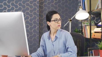 la mujer de negocios que trabaja en la oficina es pensativa. mujer de negocios trabajadora pensativa en el trabajo. video