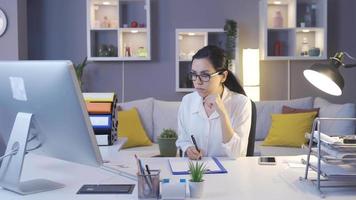 femme travaillant au bureau à domicile se réjouit. jeune femme travaille avec pc à son bureau et se réjouit. video