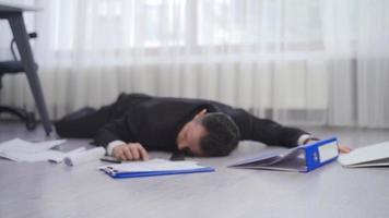 Businessman falling to the ground in the office. Businessman falling to the ground with documents and files lies on the floor. video