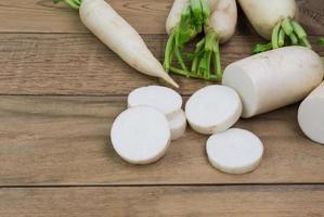 white radish on rustic wooden table with copy space - top view photo