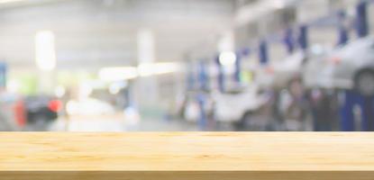 Empty wood table top with car service centre auto repair workshop blurred background photo