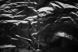 transparent plastic bag wrap overlay texture on black background photo