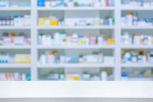 Empty white counter with pharmacy drugstore shelves blurred background photo