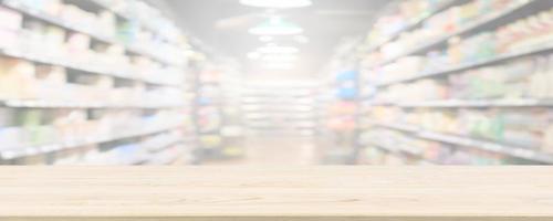 Wood table top with supermarket grocery store blurred background with bokeh light for product display photo