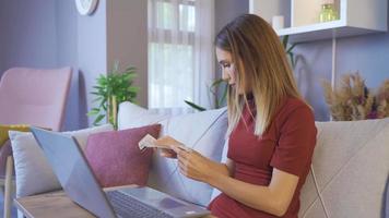 mujer pagando en línea con facturas en casa. mujer pagando facturas en línea con una computadora portátil. video
