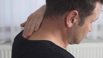 Neck pain. Man with joint pain. The neck of the man whose back is being held hurts.