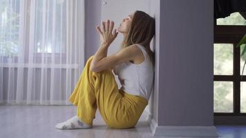 depressief vrouw zitten. de vrouw zittend Aan de vloer, leunend haar terug tegen de muur, is depressief en verdrietig. video