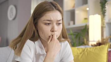 la jeune fille est réfléchie et mal à l'aise à la maison. la fille nerveuse regarde autour d'elle et est réfléchie. video