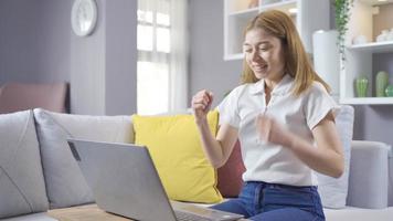 Junges Mädchen, das zu Hause mit Laptop arbeitet, freut sich. junges Mädchen, das mit Laptop arbeitet, freut sich. video