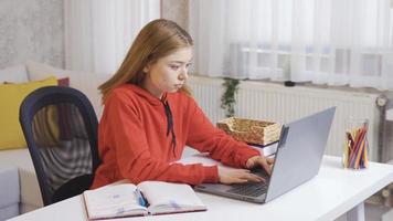 de leerling is onderwijs met een laptop, onderzoeken, vinden ideeën. meisje leerling is op zoek Bij laptop Bij huis en geeft les, onderzoekt, leert. video