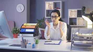 mulher de negócios jovem cansada trabalhando em seu escritório em casa. mulher olhando para seu computador e anotações está trabalhando duro e ficando cansada. video