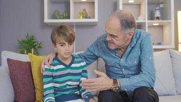 abuelo y nieto charlando en casa. el abuelo motiva a su nieto y mejora su moral. video