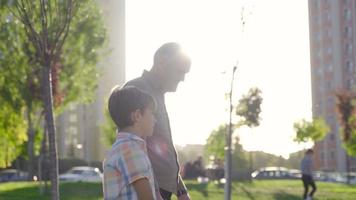 el abuelo camina y camina afuera con su nieto. el abuelo lleva a su nieto a dar un paseo. video