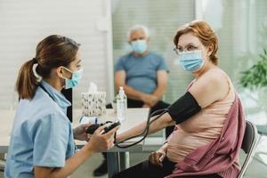 Nurse Checking The Blood Pressure Of Senior Woman photo