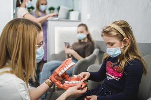 Dentist Show Model Of Teeth To Kid Patient photo