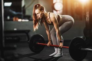 mujer en forma levantando pesas en el gimnasio foto