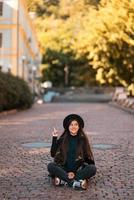 Young woman sitting at city show finger up, new idea photo