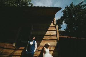 beautiful young wedding couple stands near house photo