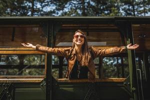 mujer saludando a través de una ventana de un tren retro foto