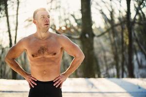 Man Doing Workout In The Forest In A Snowy Winter Day photo