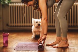 Woman Rolling Up Exercise Mat After Workout photo