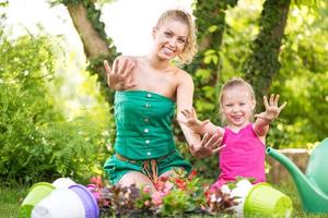 Mother and daughter planting flowers together photo