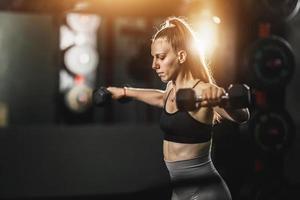 mujer musculosa entrenando con pesas en el gimnasio foto