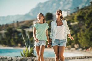 Mam And Daughter Walking Near The Sea And Enjoying Summer Vacation photo