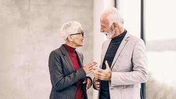 A Two Senior Business People Talking While Walking In The Office photo