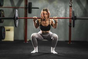 mujer haciendo ejercicio en cuclillas en el gimnasio foto