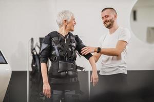 Fitness Instructor Putting An Ems Suit To A Woman photo