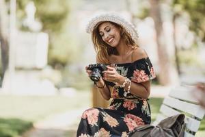 Woman Looking Photos On A Digital Camera While Enjoying Spending Time In The Park